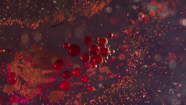 Splash Of Red Bubbles And Particles Moving Together On A Bokeh Texture Background