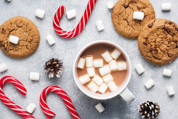 The chocolate chip cookie, Christmas cane caramel Cup cocoa and marshmallow cones Decorations on a gray background. Close up