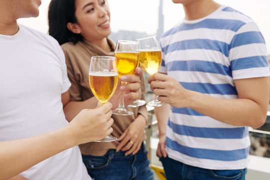 Close-up image of young people drinking beer when socializing at rooftop party