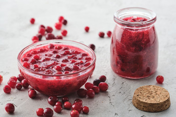 Cranberry jam in a glass bowl on a gray background.