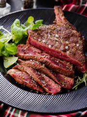 Steak on the bone. Rib eye. Tomahawk steak on the black plate with rosemary. Roasting - Rare. Entrecote