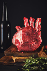 Raw beef meat on a wooden table close up on a dark background.