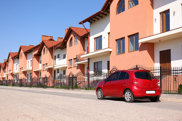 Color family car near modern buildings in city. Space for text