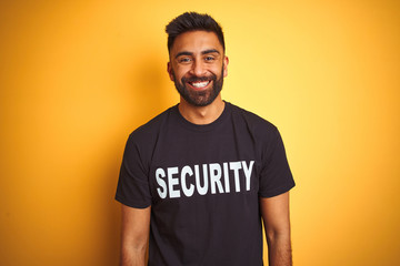 Arab indian hispanic safeguard man wearing security uniform over isolated yellow background with a happy and cool smile on face. Lucky person.