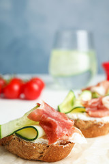 Tasty bruschettas with prosciutto served on table