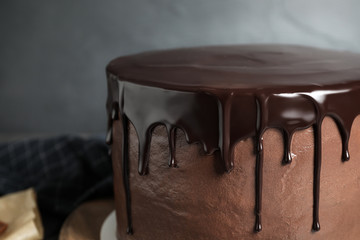 Freshly made delicious chocolate cake against grey background, closeup