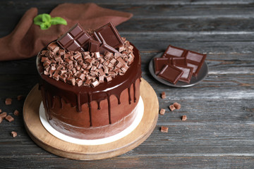 Freshly made delicious chocolate cake on black wooden table. Space for text