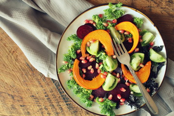 Healthy vegetarian salad, roasted pumpkin, tomato,pomegranate, kale, beet