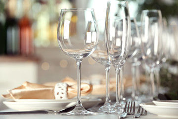 Table setting with empty glasses, plates and cutlery indoors