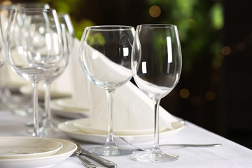 Table setting with empty glasses, plates and cutlery indoors