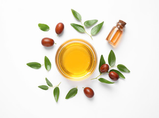 Bowl with jojoba oil and seeds on white background, top view - obrazy, fototapety, plakaty
