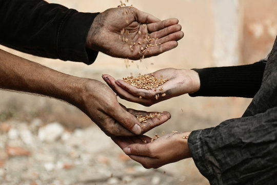 Poor homeless people sharing food outdoors, closeup