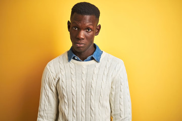 African american man wearing denim shirt and white sweater over isolated yellow background skeptic and nervous, frowning upset because of problem. Negative person.
