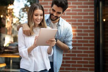 Young couple using a digital tablet together and smiling