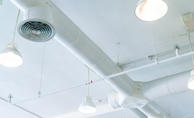 Air duct, air conditioner pipe and fire sprinkler system on white ceiling wall. Air flow and...
