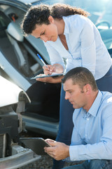 automotive dealer inspecting used car
