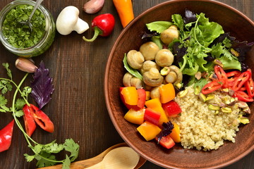 Salad with quinoa, sweet pepper, mushrooms, herbs and pistachios. Healthy nutrition. Vegetarian concept, top view, copy space