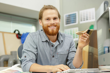 man holding a paint brush in office