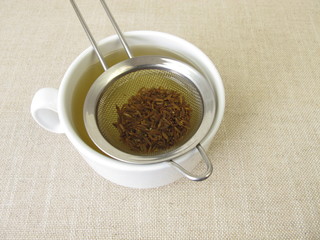 Tea from caraway seeds and caraway fruits in the tea strainer 