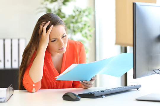 Worried busnesswoman discovering mistake on document