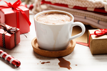 a cup of chocolate with red gift boxes