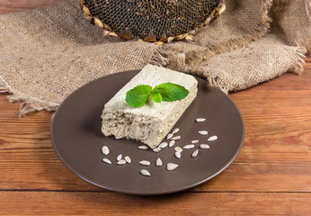 Sunflower halva and sunflower seeds against dry ripe sunflower head