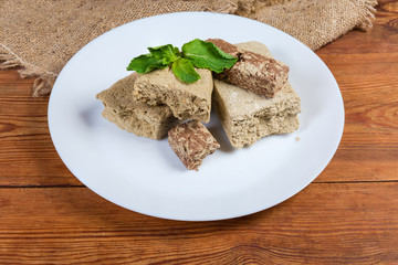 Sunflower halva with different addition, fresh mint twig on dish