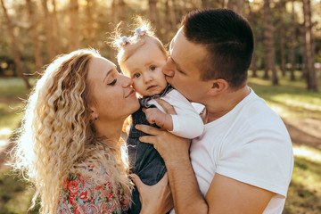 Fototapeta premium Happy family father, mother and child daughter outdoor enjoying sunset - Image