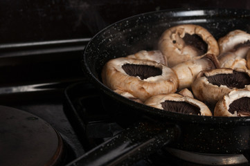 Roasting mushrooms in a black frying pan.Healthy food
