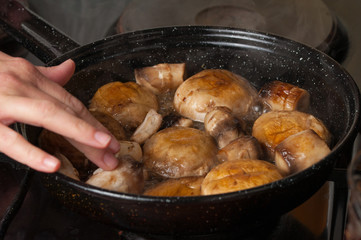 Roasting mushrooms in a black frying pan.Healthy food