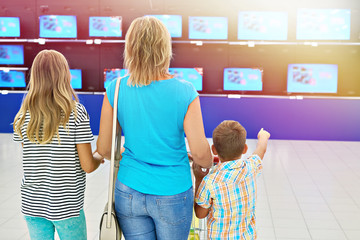 Mother with children in shop of tv
