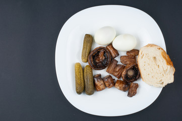 Mushrooms and boiled eggs on a white plate isolated on a black background.Natural food