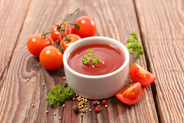 tomato sauce with pepper and parsley on wood background