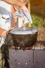 Fish soup boils in cauldron at the stake.Cooking fragrant soup