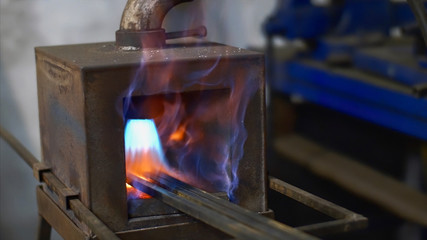 Art forging of metal products. Hot metal bars in forge gas furnace in the smithy in factory...