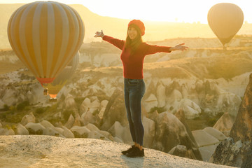 Soft focus on asian woman standing on fantastic landscape with hot air ballons in early moning at Cappadocia, Turky