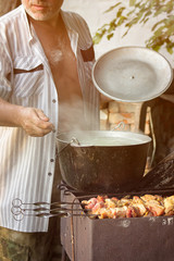Fish soup boils in cauldron at the stake.Cooking fragrant soup