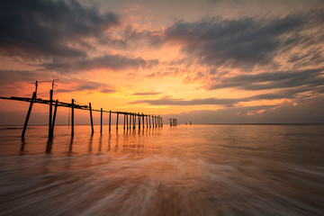 Obraz premium Beautiful of Old bridge and waves on sea at during sunset time
