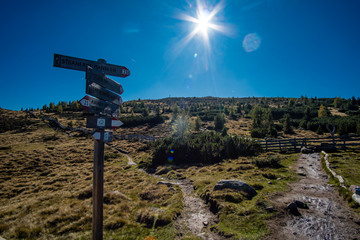 Wegweiser mit Wanderweg zu den Stoanernen Mandlen in Südtirol mit Blick in die Sternen Sonne