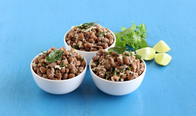 Black eyed beans or cowpea curry, an Indian vegetarian, delicious, and healthy home cooked side dish for food like chapati and roti, in three bowls, and coriander leaves and lemon slices.