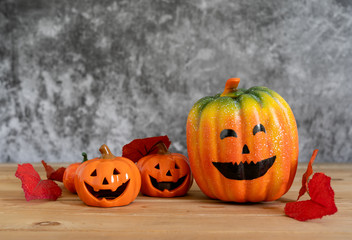Accessories of decorations Happy Halloween day background concept.Variety of Jack O Lanterns pumpkins object to party season with autumn leaves on modern rustic brown & white stone backdrop.copy space