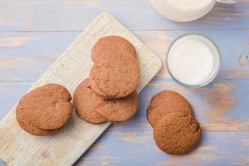 Pile of Delicious Chocolate Chip Cookies on a  board with Milk Bottles