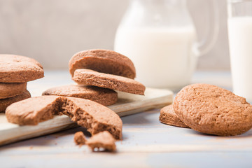 Pile of Delicious Chocolate Chip Cookies on a  board with Milk Bottles