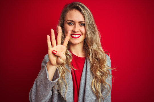 Young beautiful business woman wearing elegant jacket standing over red isolated background showing and pointing up with fingers number four while smiling confident and happy.