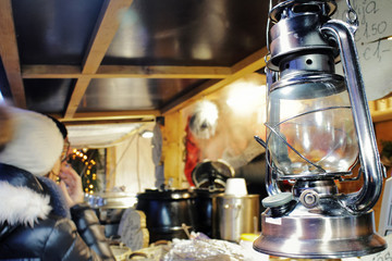 classic metal kerosene lamp or oil lantern on the blurred background of a street christmas city market at december