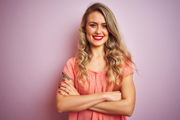 Obraz premium Young beautiful woman wearing t-shirt standing over pink isolated background happy face smiling with crossed arms looking at the camera. Positive person.