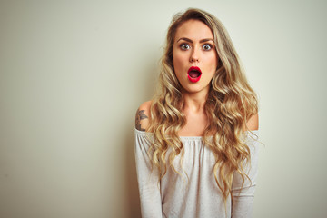 Young beautiful woman standing over white isolated background afraid and shocked with surprise expression, fear and excited face.