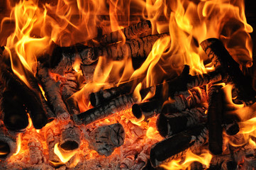 Flames from burning firewood in a fireplace close-up