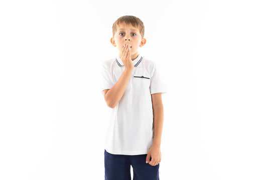 The little boy in a white shirt, blue shorts with a fair hair costs, covers with a palm of companies and will scaredly overcome in the camera
