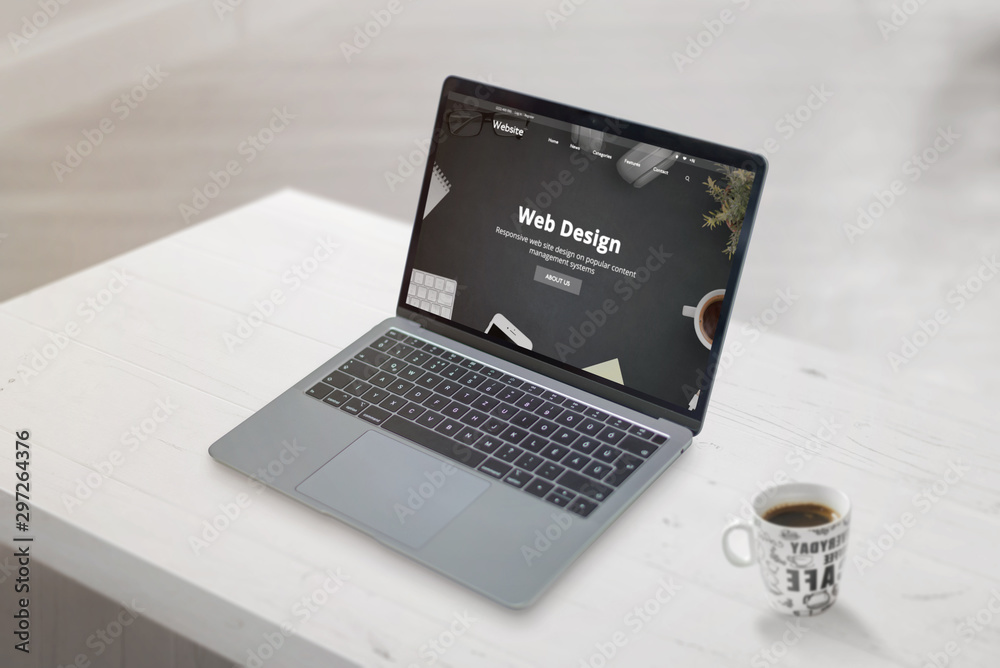 Poster Web design studio concept web page on laptop. Clean scene with cup of coffee beside. Web development or design studio concept.